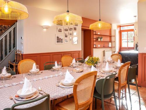 une salle à manger avec une longue table et des chaises dans l'établissement Charmante maison berrichonne avec terrasse et WIFI proche Châteauroux - FR-1-591-710, à Déols
