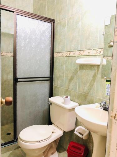 a bathroom with a toilet and a sink at Hotel casa gustadora in Cali