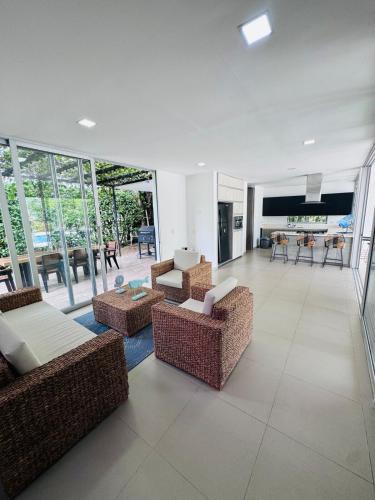 a living room with couches and tables and windows at Finca de lujo con picsina en San Jerónimo Antioquia in San Jerónimo
