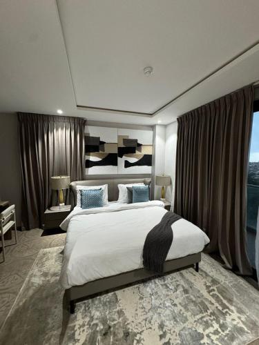 a bedroom with a large bed and a large window at Apartment Opal At The Park in Accra
