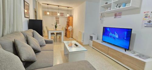 a living room with a couch and a flat screen tv at Estancia Vacacional Verín-Chaves in Verín