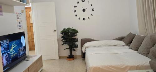 a living room with a couch and a clock on the wall at Estancia Vacacional Verín-Chaves in Verín