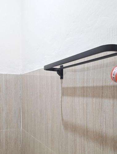 a black shower curtain in the corner of a bathroom at Tangkoko Hideaway Cottage in Pulau Mogogimbun