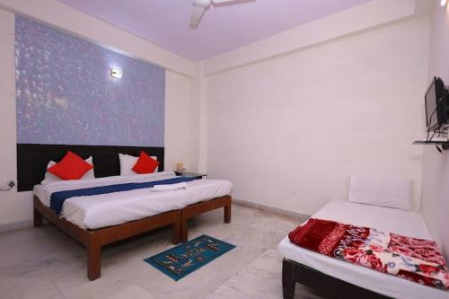 a bedroom with two beds with red pillows at R k guest house in Agra