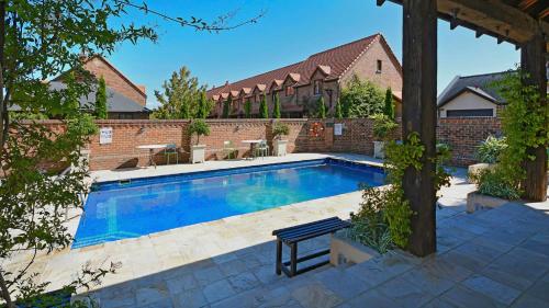 a swimming pool in a yard with a brick building at Monaco Village Apartment in Nelson