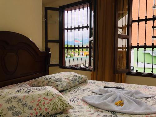 カリにあるHotel casa gustadoraの窓付きのベッド(タオル2枚付)