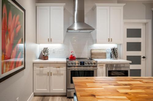 a kitchen with white cabinets and a stove top oven at Casa Evergreen - Outdoor Grille Patio with Putt in Leisure World