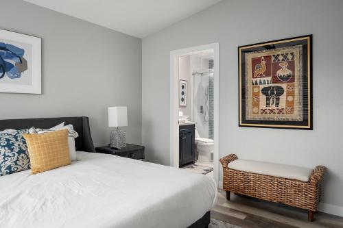 a white bedroom with a bed and a chair at Casa Evergreen - Outdoor Grille Patio with Putt in Leisure World