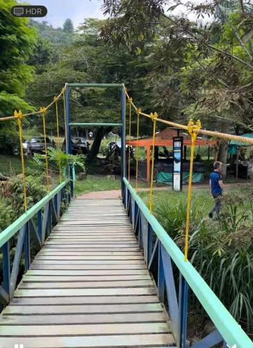 a bridge over a park with a man walking on it at Villa El Rio in Cali