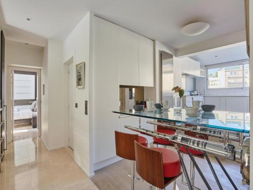 une cuisine avec un comptoir et quelques chaises rouges dans l'établissement Amazing Penthousse Foch Arc de Triomphe Trocadero, à Paris