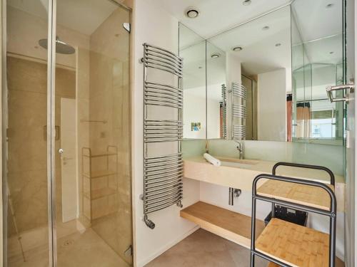 une salle de bain avec une douche, un lavabo et un miroir dans l'établissement Amazing Penthousse Foch Arc de Triomphe Trocadero, à Paris