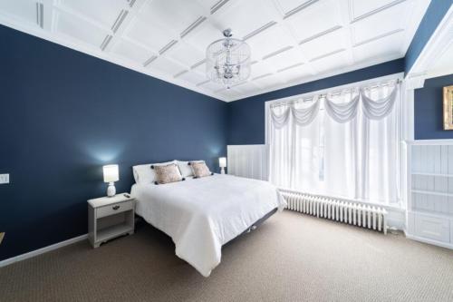 a blue bedroom with a bed and a chandelier at 210 Main St in Ellsworth