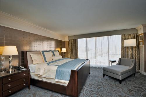 a hotel room with a bed and a chair at InterContinental Kansas City at the Plaza by IHG in Kansas City