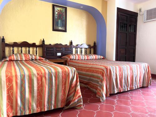 a bedroom with two beds with orange and orange sheets at Hotel Gaviota Vallarta in Puerto Vallarta