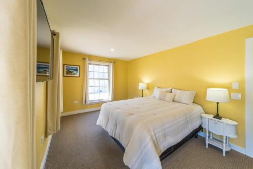 a bedroom with a large white bed and a window at 210 Main St in Ellsworth