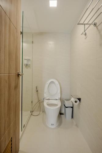 a bathroom with a toilet and a glass shower at Diff Apartel Banglamphu in Bangkok