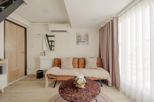a bedroom with a bed and a table with flowers on it at Diff Apartel Banglamphu in Bangkok