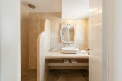 une salle de bains avec un lavabo et un miroir dans l'établissement Strogili, à Oia