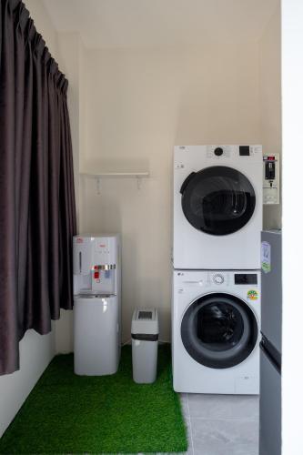 a washer and dryer in a room with green carpet at Diff Apartel Banglamphu in Bangkok