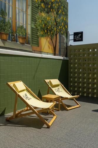 two lounge chairs sitting in front of a building at Diff Apartel Banglamphu in Bangkok