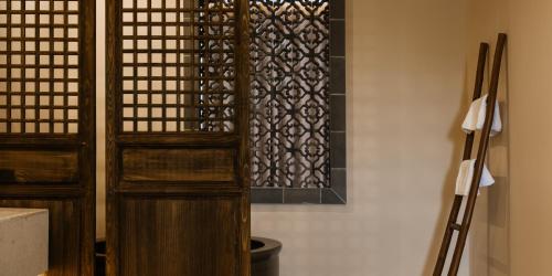 a room with two wooden doors and a window at Huangshan Yixian Pumanmanju Hotel in Huangshan