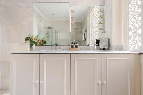 a white bathroom with a sink and a mirror at Secluded Modern Private Apartment by Buckingham Palace in London