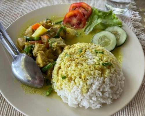 a white plate of food with rice and vegetables at Renny's Tangkoko Safety Stop in Bitung