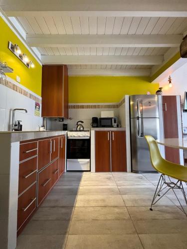 a kitchen with wooden cabinets and stainless steel appliances at Cabañas Sublime Bolson in El Bolsón