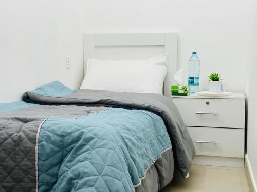 a bedroom with a bed and a white dresser at Cornich Street - Pearl Room in Abu Dhabi