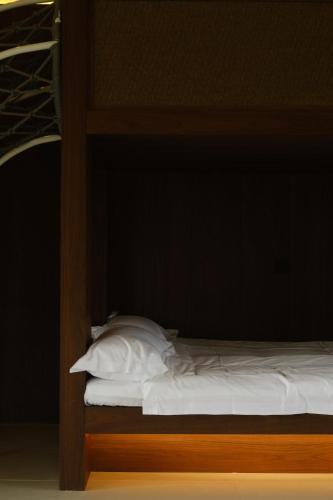 a bunk bed with white sheets and pillows on it at Huangshan Yixian Pumanmanju Hotel in Huangshan