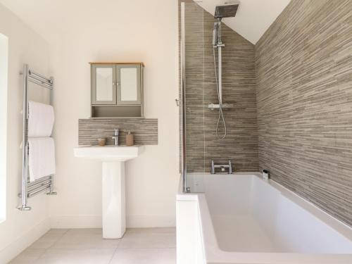 a bathroom with a sink and a bath tub at Derwen House in Llangollen