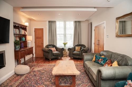 a living room with couches and a coffee table at 5 Bed Luxury Townhouse with Hot Tub, Rooftop Terrace, Perfect for Groups, Near Cruise Terminal in Southampton