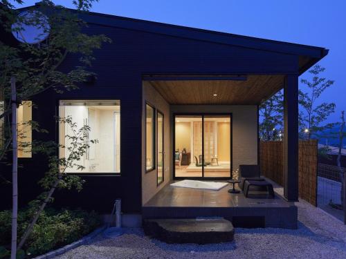 a modern house with a black facade at 宮島離れの宿 IBUKU -Miyajima Hanare no Yado IBUKU- in Miyajima