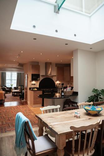 a kitchen and living room with a wooden table at 5 Bed Luxury Townhouse with Hot Tub, Rooftop Terrace, Perfect for Groups, Near Cruise Terminal in Southampton
