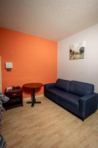a living room with a blue couch and a table at Scottish Inns & Suites - North Hershey in Harrisburg