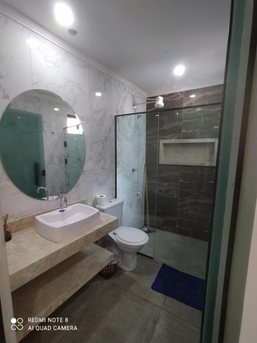 un bagno con un water, un lavandino e uno specchio di Casa Pirenópolis a Pirenópolis