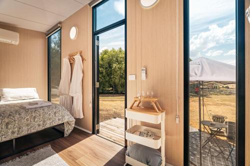 a bedroom with a bed and a sliding glass door at Fassifern Tiny House 1 by Tiny Away in Lancefield