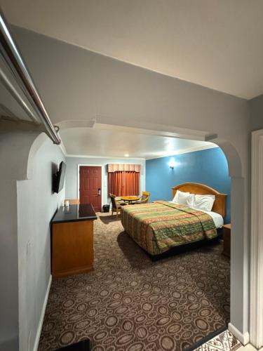 a hotel room with a bed and a desk at Sunset Inn & Suites in Gardena