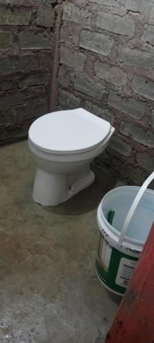 a white toilet sitting next to a brick wall at Cena Homestay in Rejeng