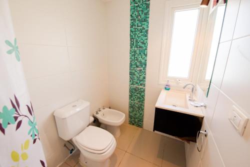 a white bathroom with a toilet and a sink at departamento vida in Ushuaia