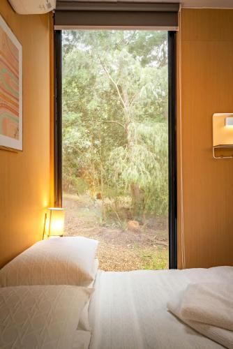 a bedroom with a window looking out at a forest at Forest Nook Tiny House by Tiny Away in Buffalo