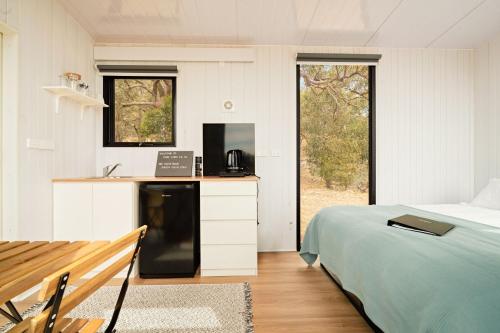 ein Schlafzimmer mit einem Bett und einem Schreibtisch mit einem Laptop in der Unterkunft Gem near the Dam by Tiny Away in Romsey