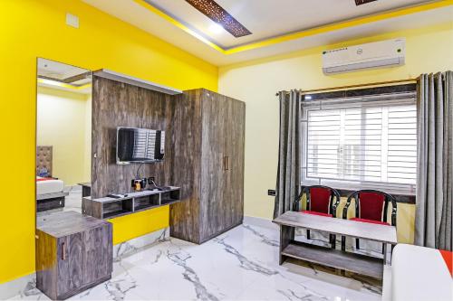 a room with yellow walls and wooden partition with red chairs at Hotel O SRI SAI PALACE in Bārang