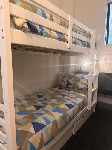 a bedroom with two bunk beds with a bed at Gamma Hotel in Auckland