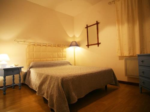 une chambre avec un lit, une table et une lampe dans l'établissement Charmant gîte au château rénové, parc privé, 2 chambres, proche Nevers et circuit Magny Court - FR-1-489-163, à Le Veurdre