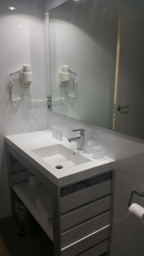 a bathroom with a white sink and a mirror at Hotel Art Santander in Santander