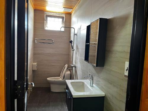 a bathroom with a toilet and a sink at Homestay Nhà Mộc in Da Lat