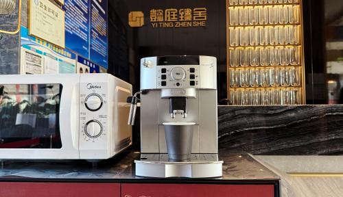 a coffee maker is sitting next to a microwave at THE YARD HOTEL BEIJING,BianyiFang - steps The Forbidden City - strolling through the imperial gardens is incredibly easy - The guest rooms blend modern comfort with Chinese charm - Peking duck - living in history Your Beijing adventure begins here in Beijing
