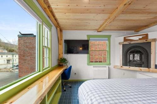 a bedroom with a bed and a fireplace at Downtown Camden Hotel in Camden