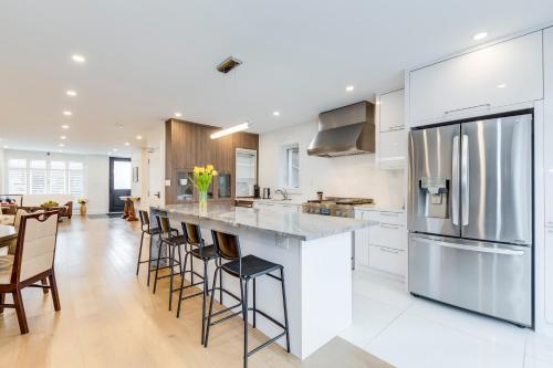 トロントにあるToronto Midtown Home Suitesの白いキャビネットとバースツール付きの大きな島のあるキッチンが備わります。